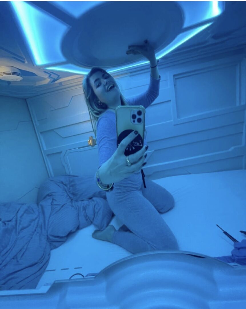 Κοπέλα που βγάζει σέλφι μέσα σε ένα δωμάτιο με μπλε φωτισμό