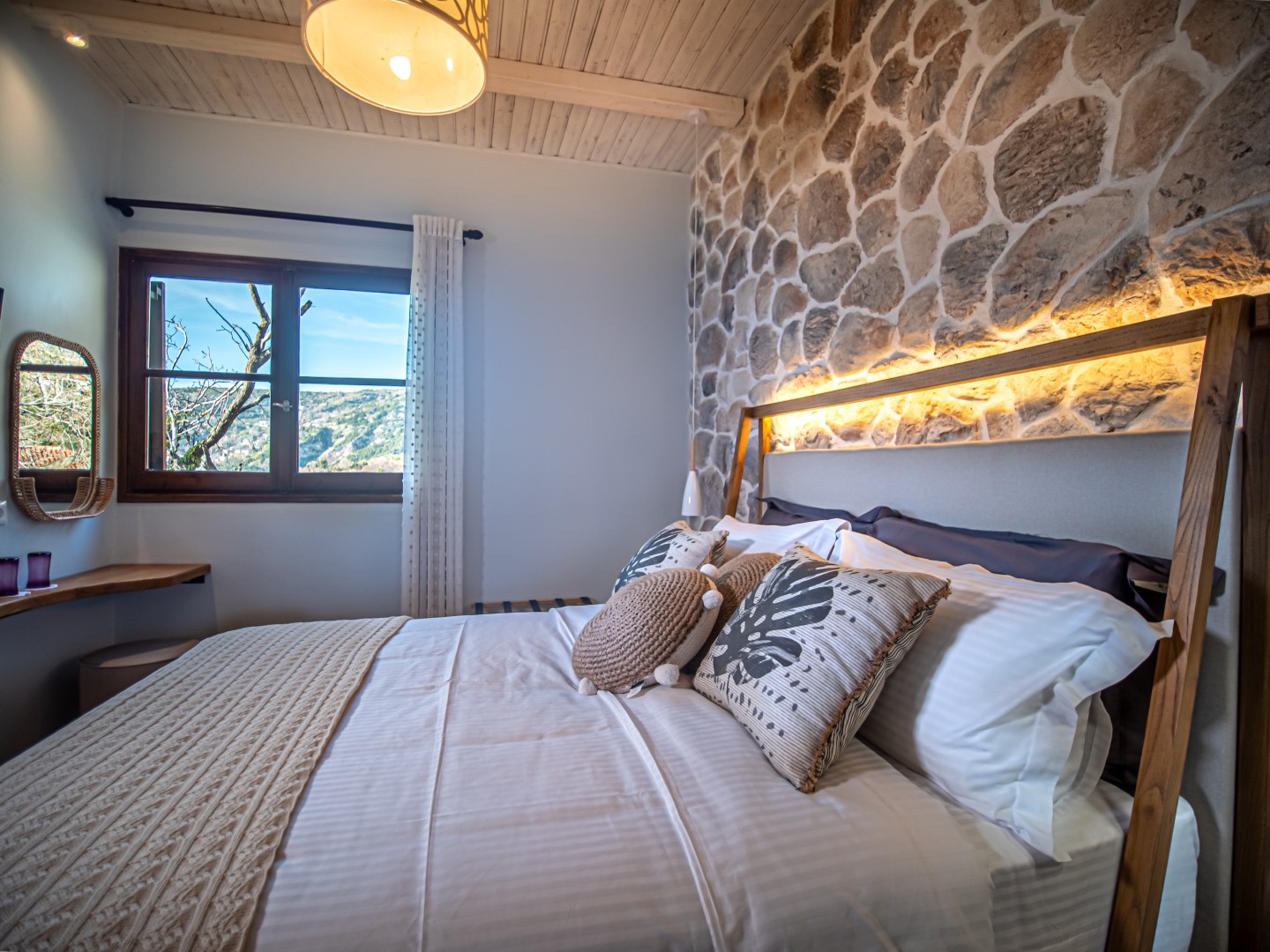 Δωμάτιο με διπλό κρεβάτι και πέτρινο τοίχο