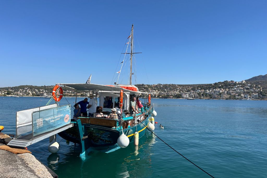 Μια μικρή βάρκα σε λιμάνι με κόσμο πάνω