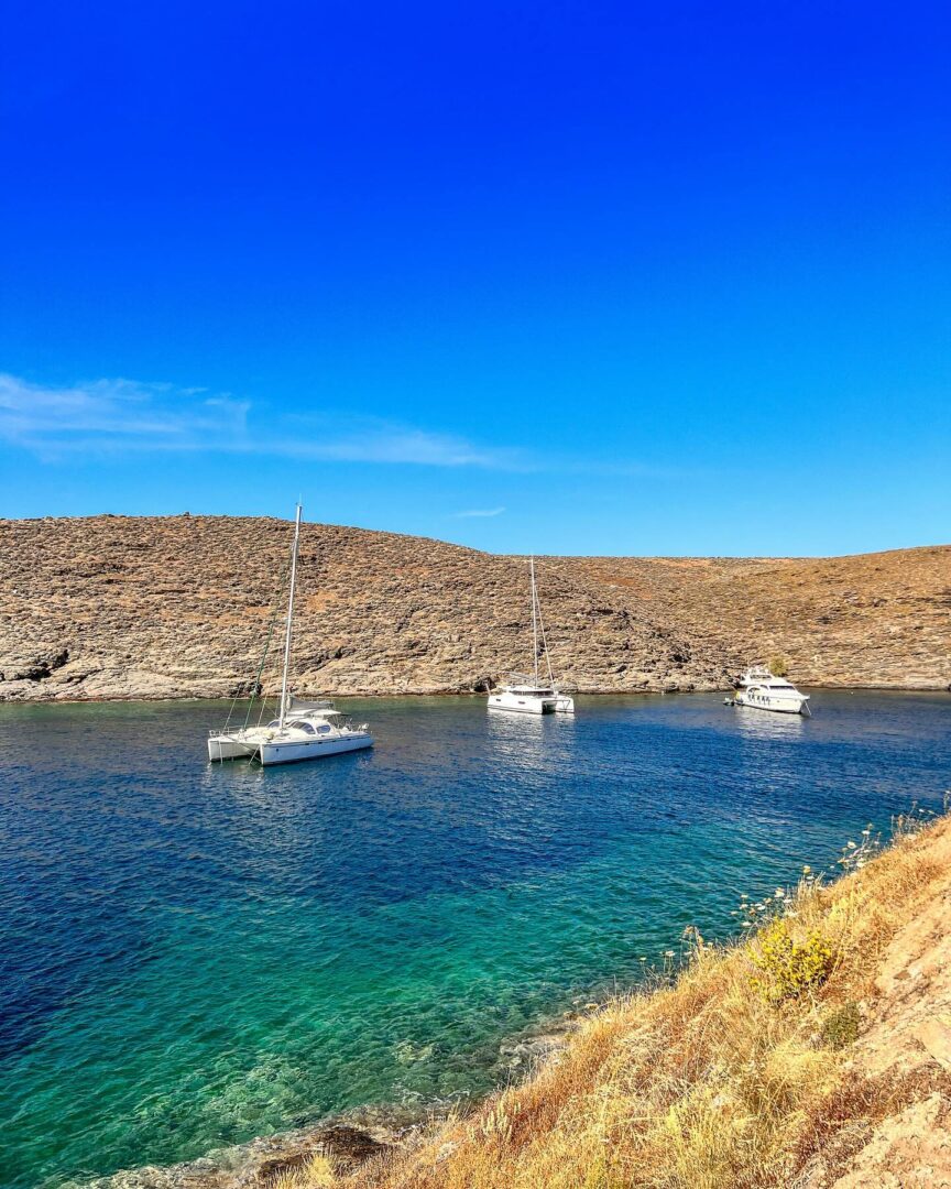 Θάλασσα με τρία σκάφη και τριγύρω βράχια