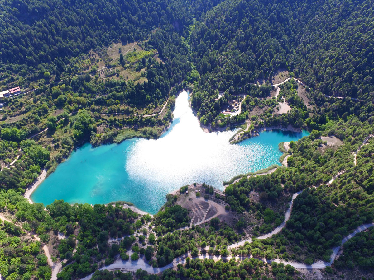 Λίμνη από ψηλά με καταπράσινα βουνά γύρω γύρω